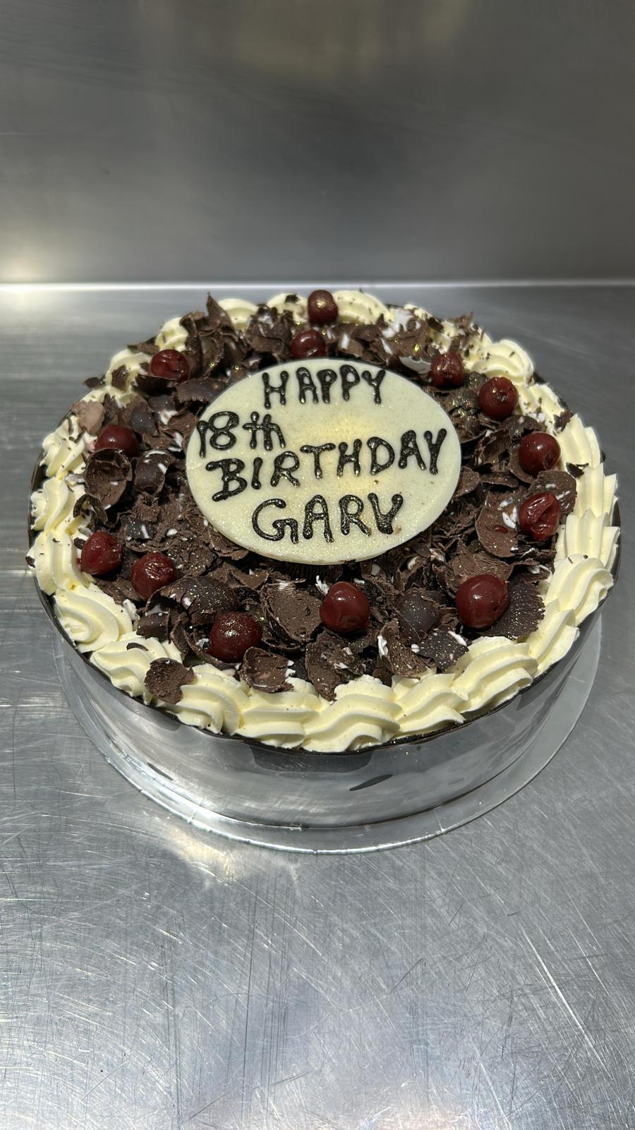 Black Forest birthday cake with chocolate shavings and cherries