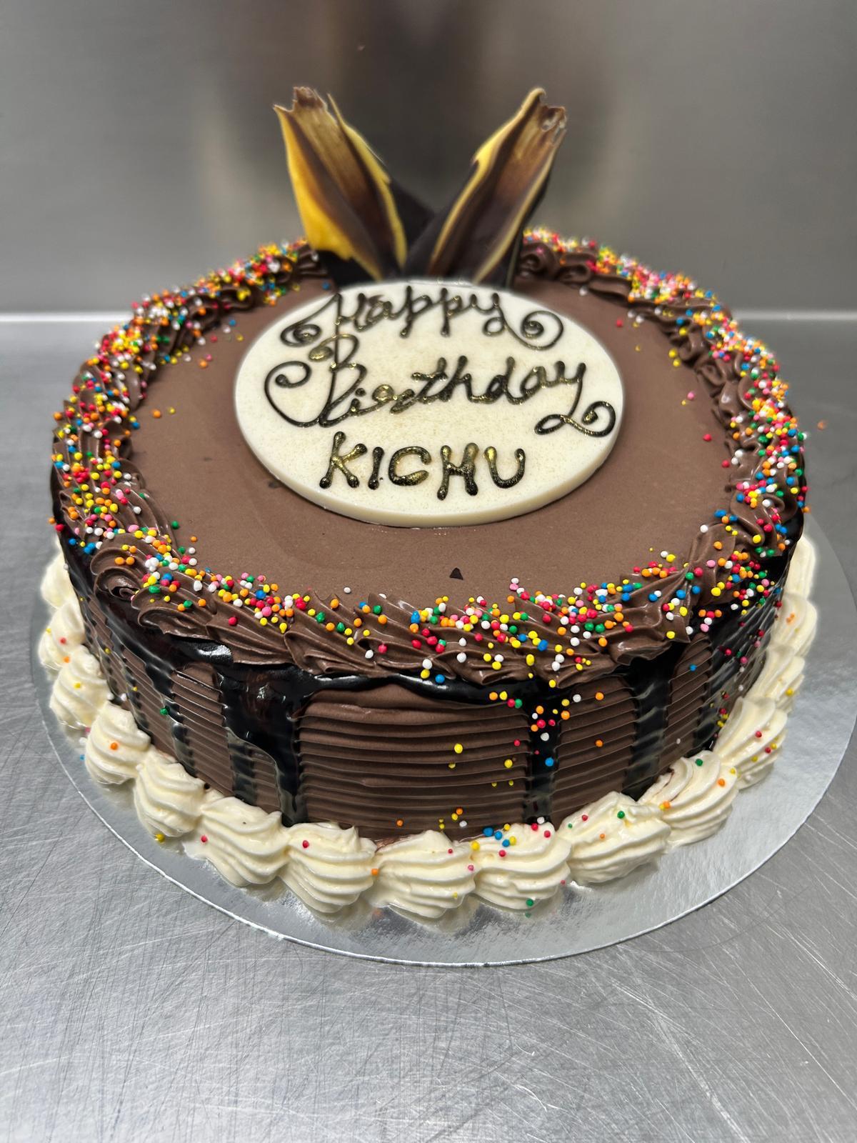 Chocolate birthday cake with rainbow sprinkles and gold leaf