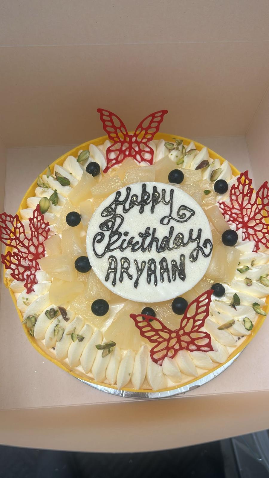 Birthday cake with pineapple and butterfly sugar art decorations